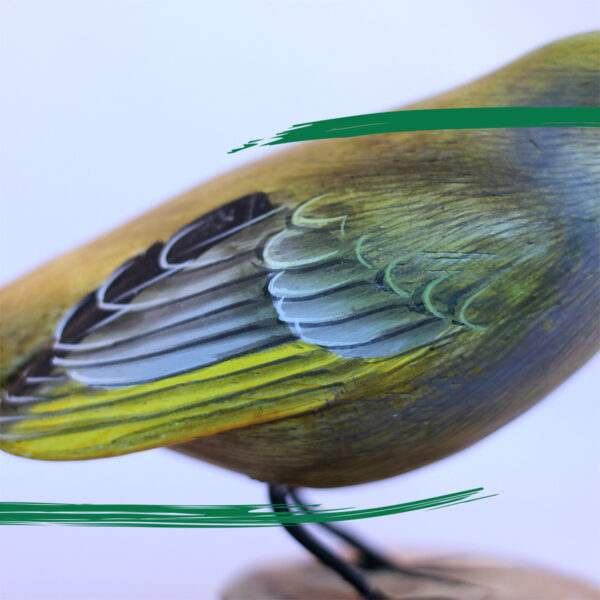 A detail shot of a Wooden Greenfinch on a log ornament from Shiny Happy Eco
