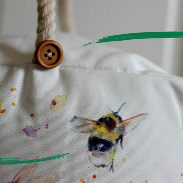Close up detail of illustrated bee and button on doorstop from Shiny Happy Eco