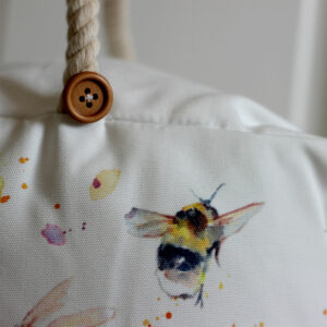 Close up detail of illustrated bee and button on doorstop from Shiny Happy Eco online gift store