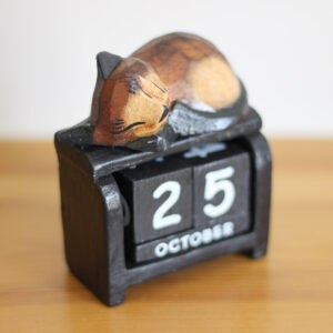 Cat sleeping on calendar ornament in dark brown colourings on black available from Shiny Happy Eco.