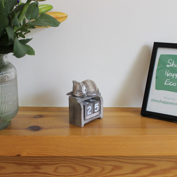 Sleeping Cat calendar ornament in light brown colourings on a mantlepiece available from Shiny Happy Eco.