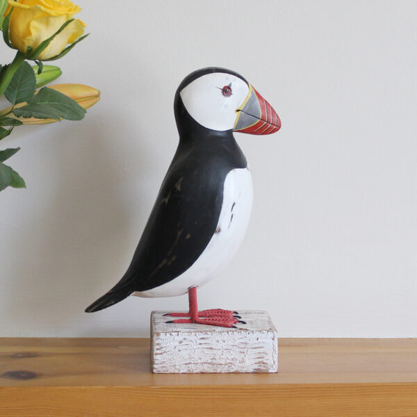 Wooden Puffin ornament on a mantlepiece, hand made and painted in a rustic style and available from Shiny Happy Eco.