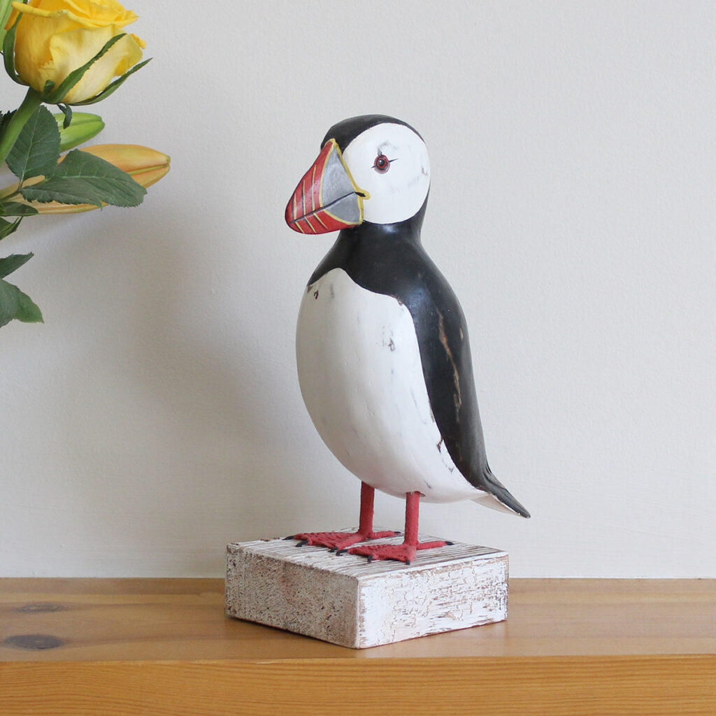 Wooden Puffin ornament on a plinth, hand made and painted in a rustic style and available from Shiny Happy Eco.
