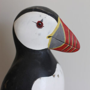 Close up of the head of a Wooden Puffin ornament, hand made and painted in a rustic style and available from Shiny Happy Eco.