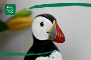 close up of a wooden puffin ornament, one of our favourite eco friendly gifts of 2025