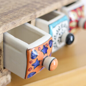 Close up of open drawers in Wooden mini chest of 3 colourful ceramic drawers available from Shiny Happy Eco