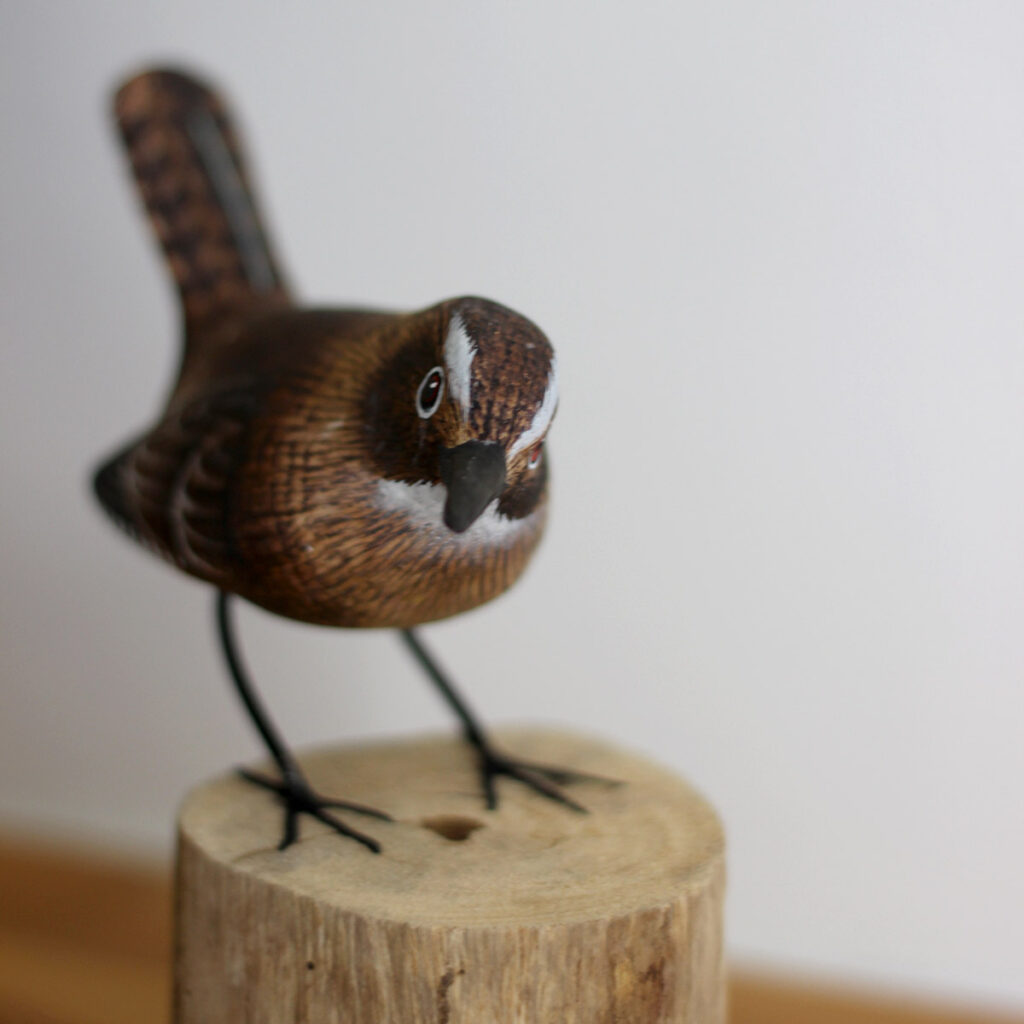 Close up of Hand carved and painted Wooden Wren Ornament on driftwood available from Shiny Happy Eco.